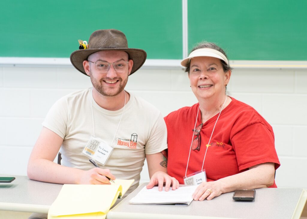 Two people in hats smile for a photo.
