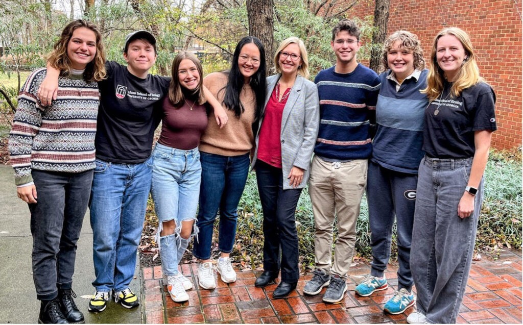 Ecology School dean poses with seven undergraduate students.